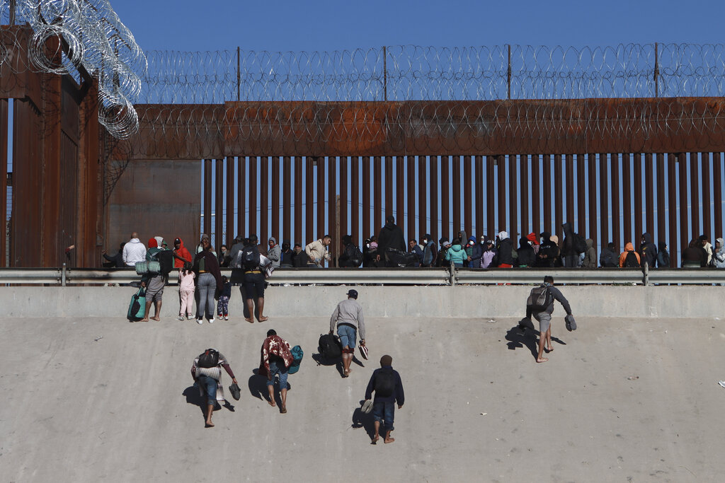 Migrants approach the border wall at Ciudad Juarez, Mexico, on the other side of the border from El Paso, Texas, December 21, 2022.