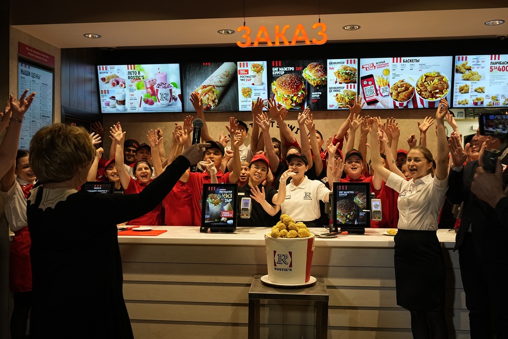Employees of Rostic's restaurant in Tverskaya street celebrate opening ceremony in Moscow, Russia, Tuesday, April 25, 2023. Former KFC restaurants, which were rebranded after the U.S. chain left Russia, opened their doors as Rostic's in Moscow on Tuesday. (