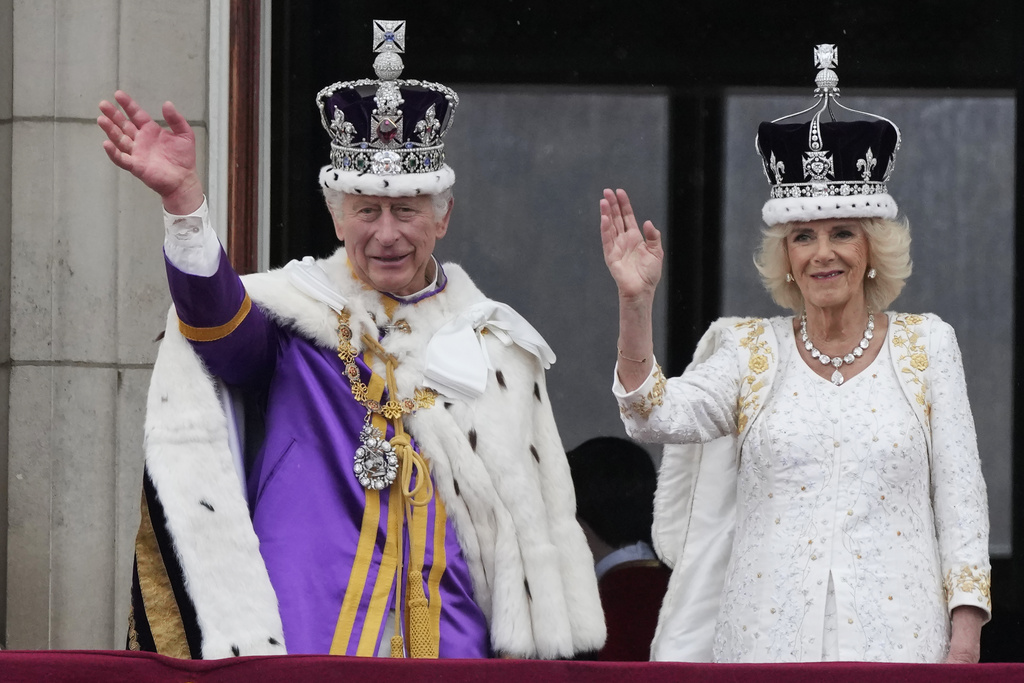 Britain's King Charles III and Queen Camilla wave to the crowds from the balcony of Buckingham Palace after the coronation ceremony in London, Saturday, May 6, 2023.