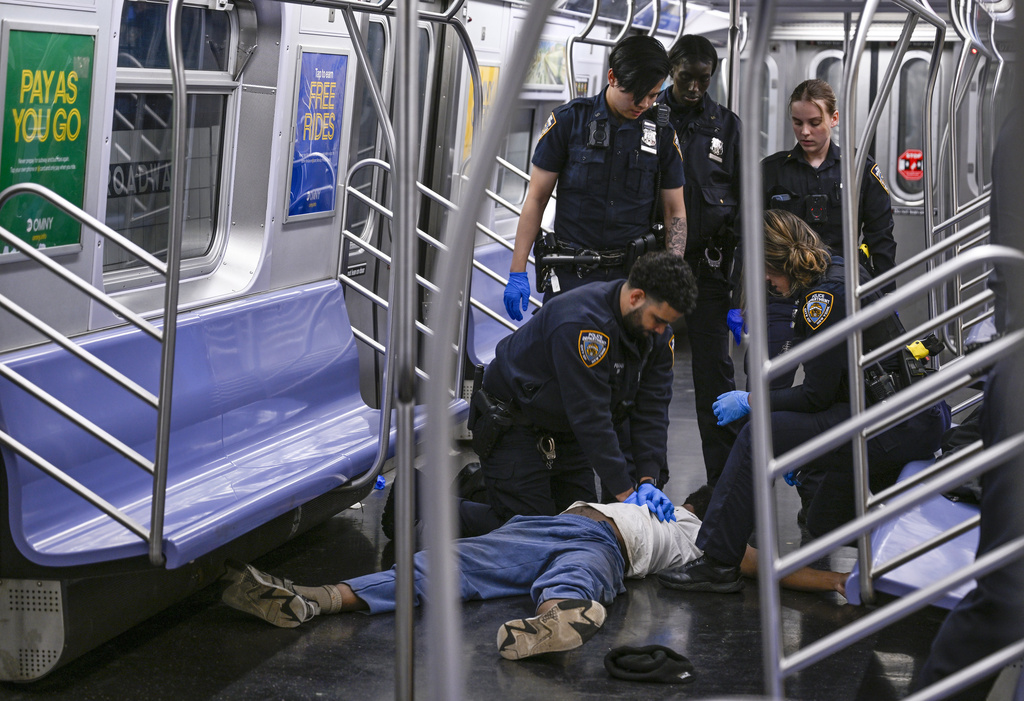 New York police officers administer CPR to a man at the scene of a reported fight on a subway train, Monday, May 1, 2023, in New York. A man suffering an apparent mental health episode aboard a New York City subway died Monday after another rider put him in a headlock, according to police officials and a video of the encounter. Jordan Neely, 30, was screaming and pacing aboard an F train in Manhattan, witnesses and police said, when another passenger knocked him to the ground.