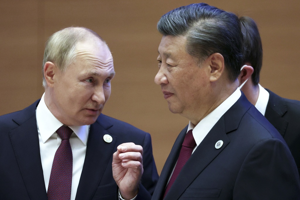 FILE- Russian President Vladimir Putin, left, gestures while speaking to Chinese President Xi Jinping during the Shanghai Cooperation Organization (SCO) summit in Samarkand, Uzbekistan, Sept. 16, 2022. Putin will this week participate in his first multilateral summit since an armed rebellion rattled Russia. Analysts say his participation at a virtual summit of the Shanghai Cooperation Organization on Tuesday is an opportunity to show he is in control after a short-lived insurrection by Wagner mercenary chief Yevgeny Prigozhin. . (