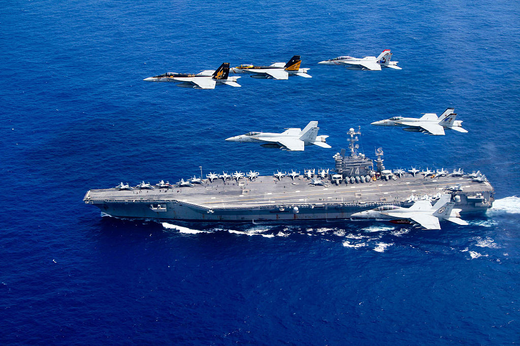 PHILIPPINE SEA - JUNE 18: In this handout provided by the U.S. Navy, a combined formation of aircraft from Carrier Air Wing (CVW) 5 and Carrier Air Wing (CVW) 9 pass in formation above the Nimitz-class aircraft carrier USS John C. Stennis (CVN 74). The formation included F/A-18 Hornets from the Black Aces of Strike Fighter Squadron (VFA) 41, the Diamondbacks of Strike Fighter Squadron (VFA) 102, the Eagles of Strike Fighter Squadron (VFA) 115, the Royal Maces of Strike Fighter Squadron (VFA) 27, the Vigilantes of Strike Fighter Squadron (VFA) 151, and the Warhawks of Strike Fighter Squadron (VFA) 97. The Nimitz-class aircraft carriers USS John C. Stennis and USS Ronald Reagan (CVN 76) are conducting dual aircraft carrier strike group operations in the U.S. 7th Fleet area of operations in support of security and stability in the Indo-Asia-Pacific. (Photo by