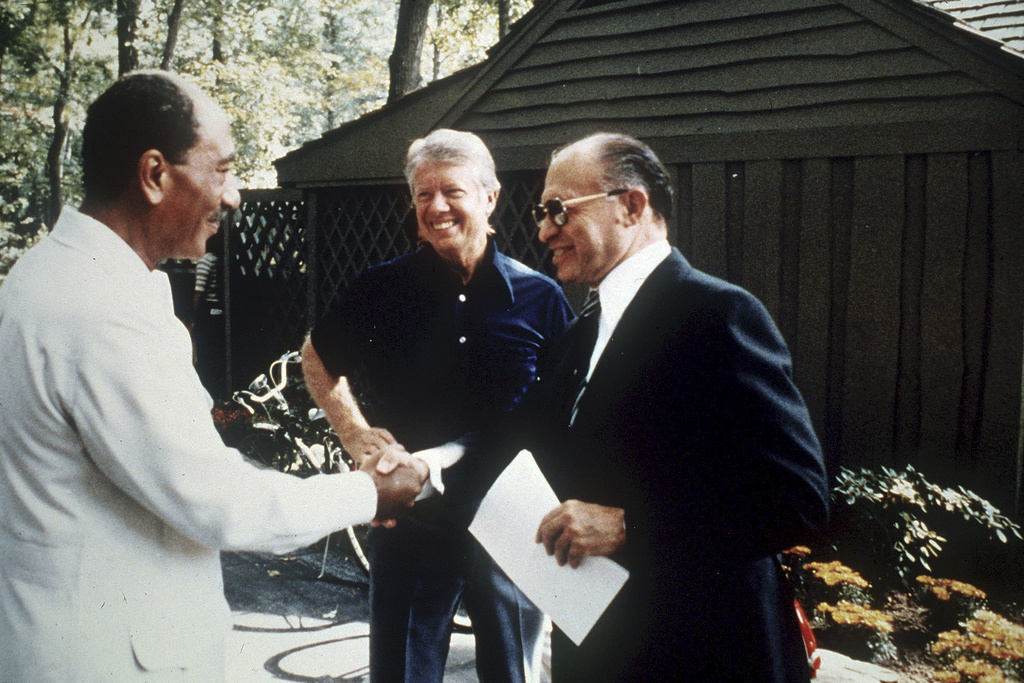 FILE - Egypt's President Anwar Sadat, left, shakes hands with Israeli Prime Minister Menachem Begin as U.S. President Jimmy Carter, center, looks on at Camp David, Md., Sept. 7, 1978. (