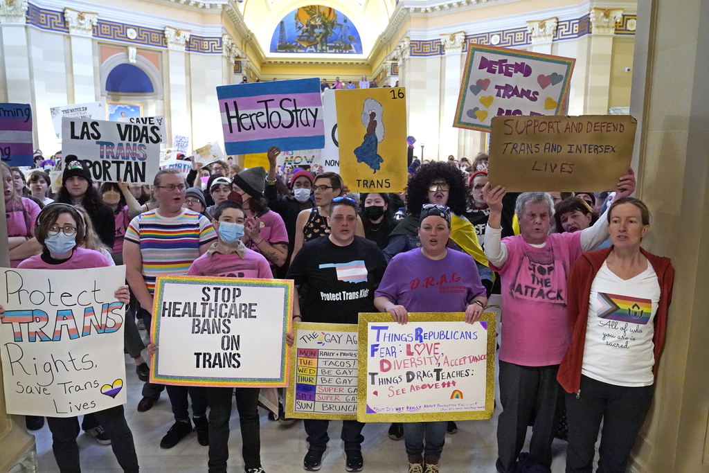 FILE - Trans-rights activists protest outside the House chamber at the Oklahoma Capitol before the State of the State address, Feb. 6, 2023, in Oklahoma City. On Monday, May 1, Oklahoma became the latest state to ban gender-affirming medical care for minors as Republican Gov. Kevin Stitt signed a bill that makes it a felony for health care workers to provide children with treatments that can include puberty-blocking drugs and hormones.
