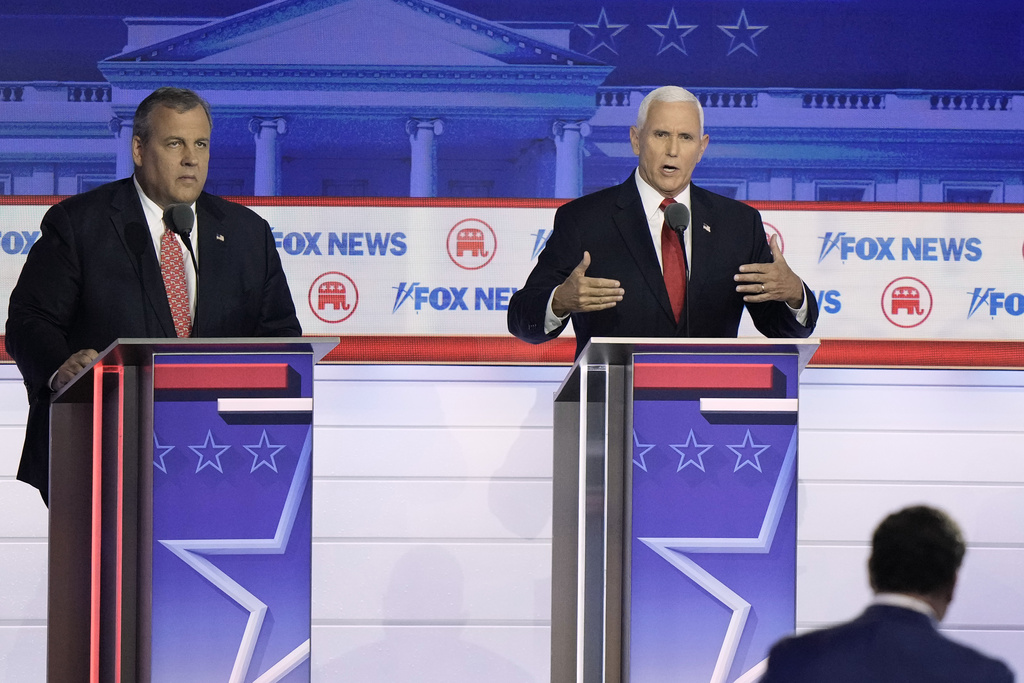 Former Vice President Mike Pence speaks as former New Jersey Gov. Chris Christie listens during a Republican presidential primary debate hosted by FOX News Channel Wednesday, Aug. 23, 2023, in Milwaukee.