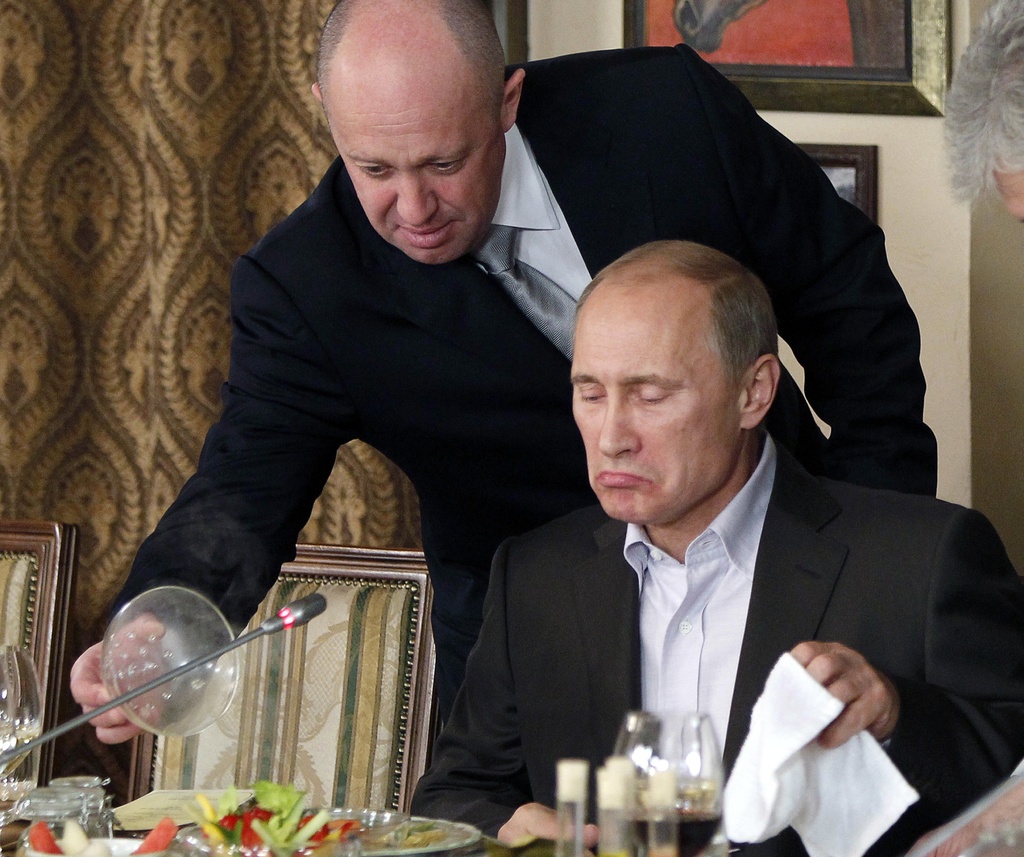 Yevgeny Prigozhin, top, serves food to Russian Prime Minister Vladimir Putin at Prigozhin's restaurant outside Moscow, Russia, on Nov. 11, 2011. When Prigozhin launched his armed rebellion that challenged the Kremlin, Western officials predicted Putin would seek vengeance against the mercenary leader. Although authorities have not yet confirmed the death of Prigozhin and his top lieutenants in Wednesday's plane crash northwest of Moscow, it sent an immediate chill through Russian official circles. The message was clear: Anyone who dares to cross the Kremlin will perish. (AP Photo/File)
