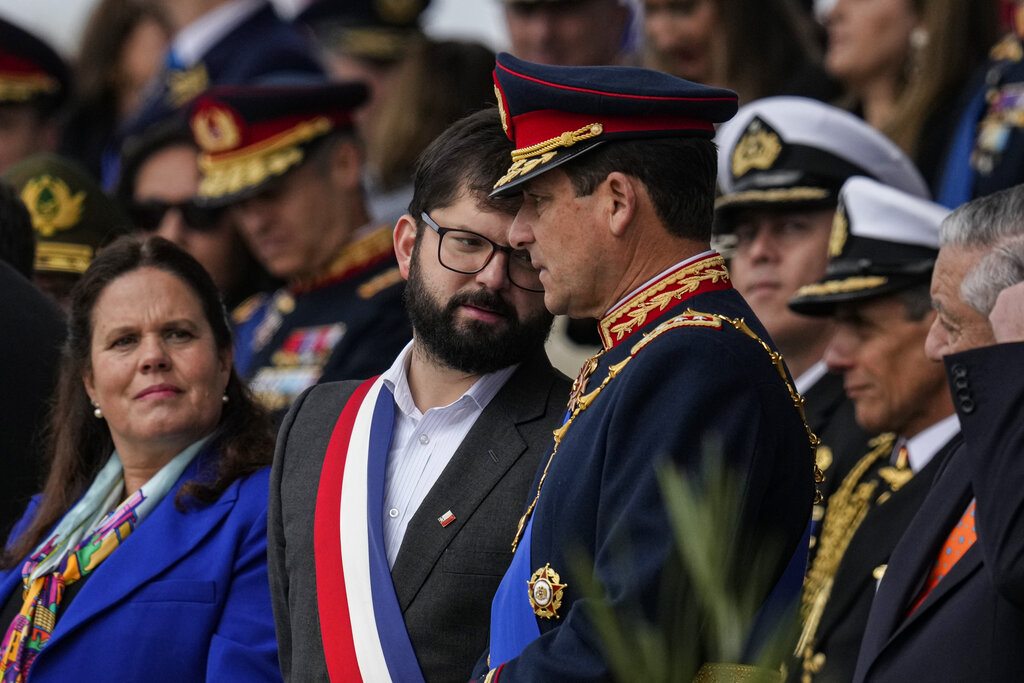 Chile's President Gabriel Boric talks to Chile's Army Commander, Gen. Javier Iturraga, right, next to Chilean Defense Minister Maya Fernandez Allende, left, during a military parade to celebrate Independence Day in Santiago, Chile, Monday, Sept. 19, 2022.