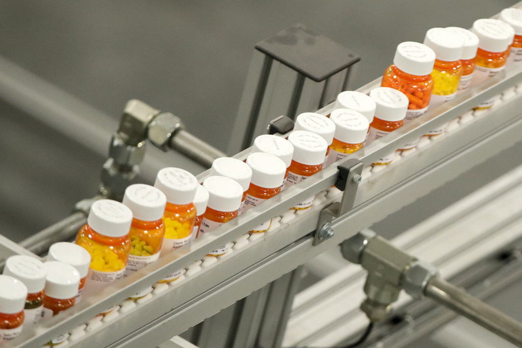 FILE- Bottles of medicine ride on a belt at a mail-in pharmacy warehouse in Florence, N.J., July 10, 2018. President Joe Biden's administration will announce on Tuesday, Aug. 29, 2023, the first prescription drugs being targeted by the U.S. government for price negotiations as part of an effort to lower Medicare costs. (