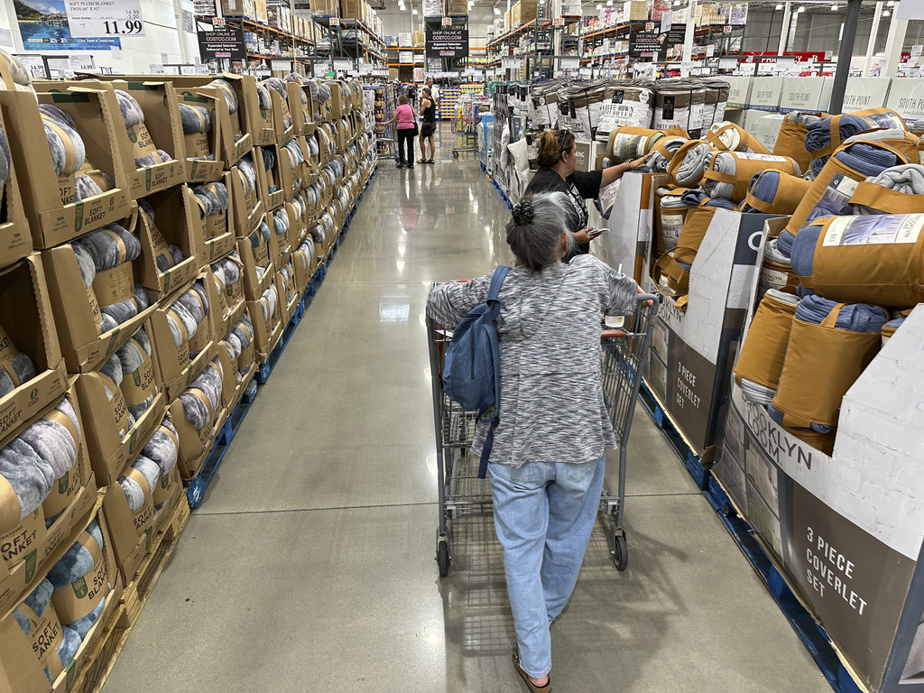 Shoppers look over blankets on sale in a Costco warehouse on August 24, 2023, at Sheridan, Colorado.