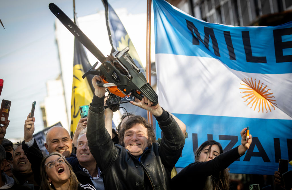 BUENOS AIRES, ARGENTINA - SEPTEMBER 25: Presidential candidate Javier Milei of La Libertad Avanza lifts a chainsaw next to Buenos Aires province governor candidate Carolina Piparo of La Libertad Avanza during a rally on September 25, 2023 in San Martin, Buenos Aires, Argentina. (Photo by