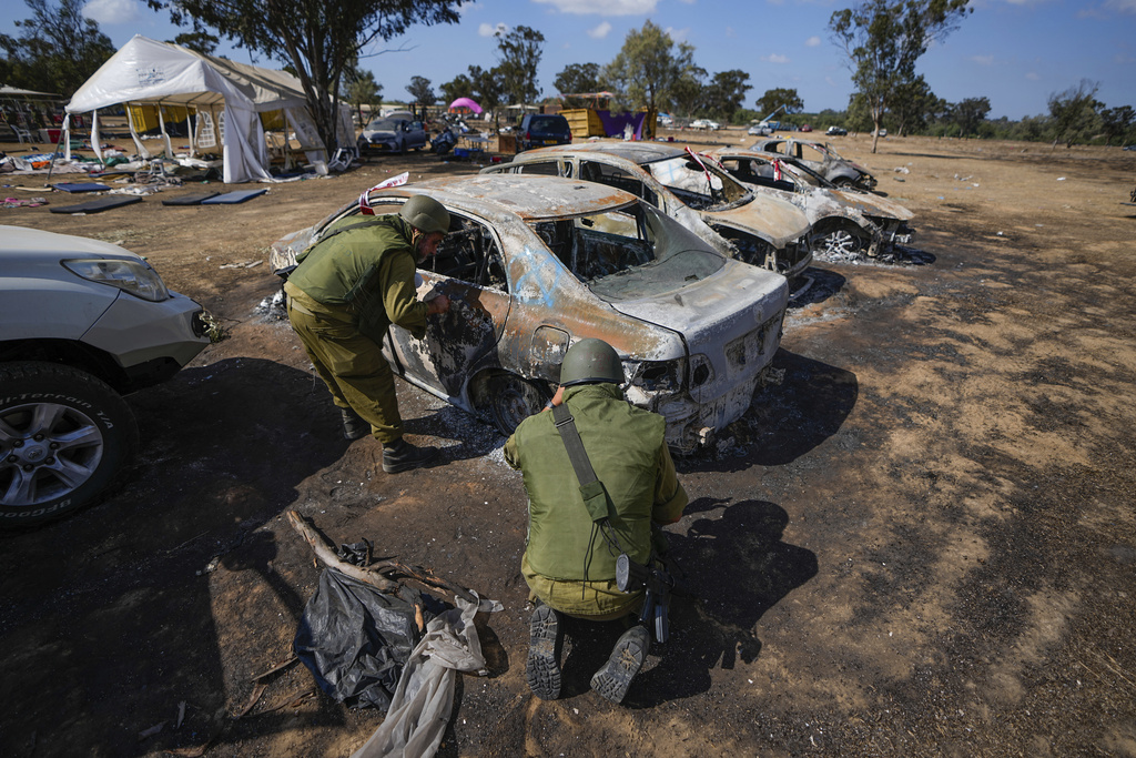 Israeli soldiers inspect the site of the Nova music festival near the border with the Gaza Strip in southern Israel.