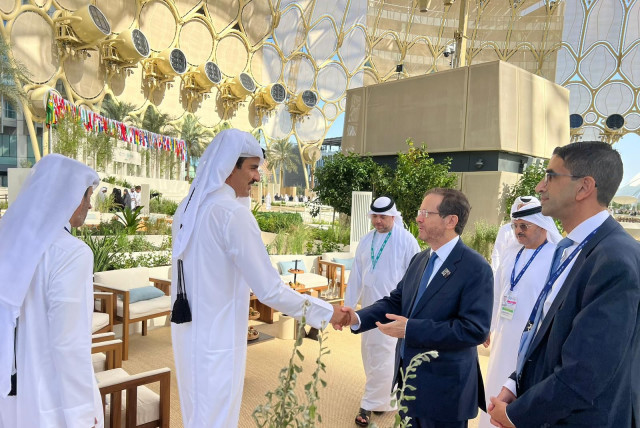 President Herzog, right, shakes hands with the emir of Qatar, Tamim bin Hamad Al Thani.