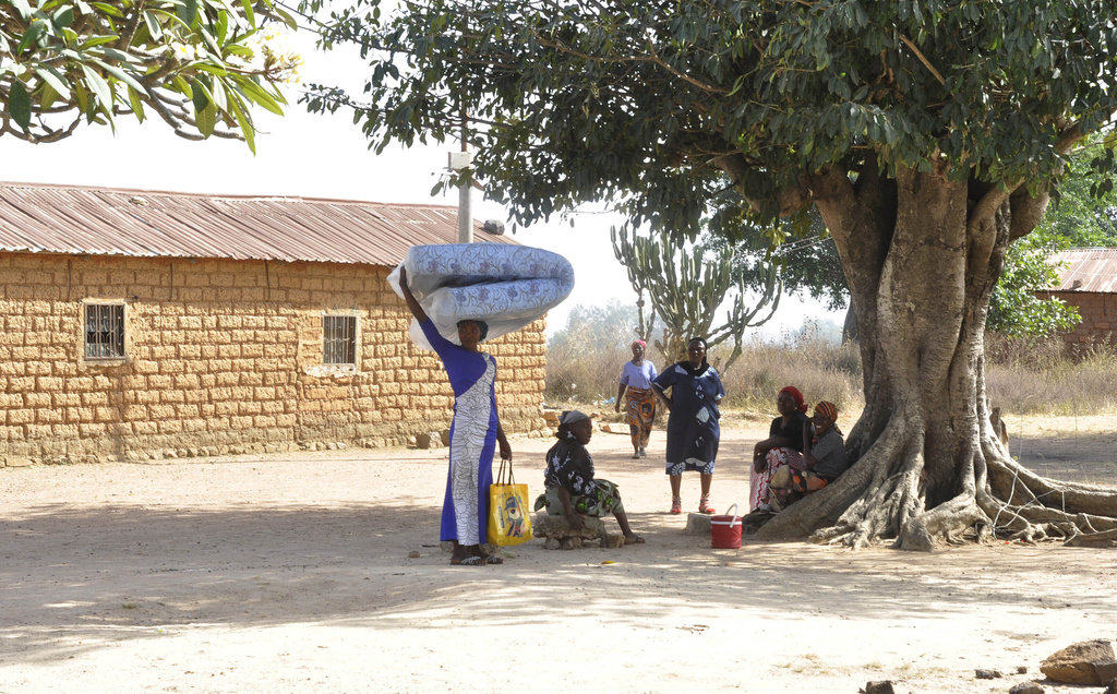 A woman carries a mattress on her head as she flees following an attacked by gunmen in Bokkos, north central Nigeria, Tuesday, Dec. 26, 2023. Nigerian officials and survivors say at least 140 people were killed by gunmen who attacked remote villages in north-central Nigeria's Plateau state in the latest of such mass killings this year blamed on the West African nation's farmer-herder crisis.