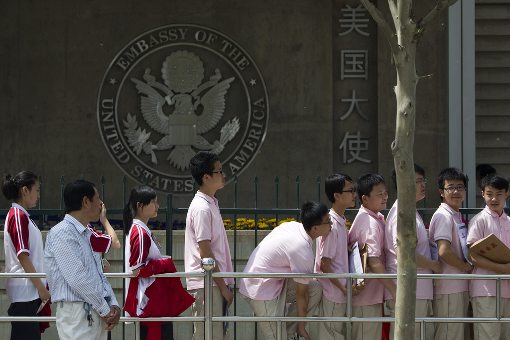 Chinese students wait outside the U.S. Embassy for their visa application interviews on May 2, 2012, at Beijing.
