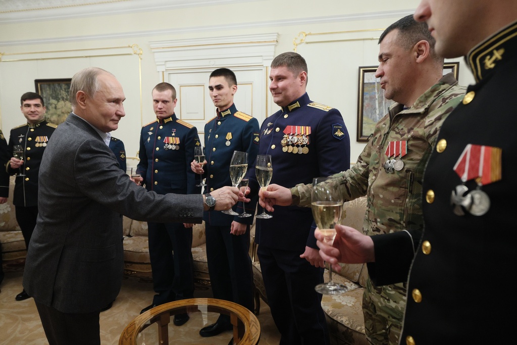 FILE - Russian President Vladimir Putin, left, shares a toast with Russian servicemen during a meeting at the Novo-Ogaryovo State residence outside Moscow, Russia, on Monday, Jan. 1, 2024. With the fighting in Ukraine now entering its third year, Putin hopes to achieve his goals by biding his time and waiting for Western support for Ukraine to wither while Moscow maintains its steady military pressure along the front line.