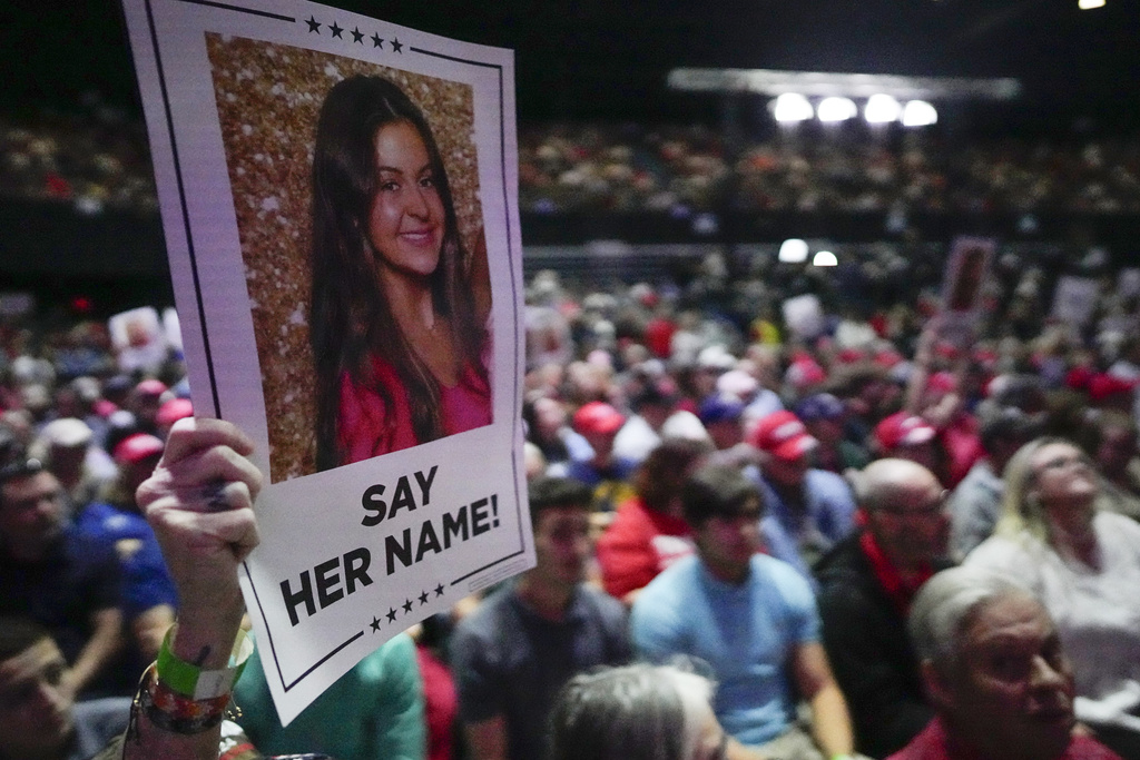 A supporter holds a poster with a photo of Laken Riley before President Trump speaks at a campaign rally Saturday at Rome Georgia.