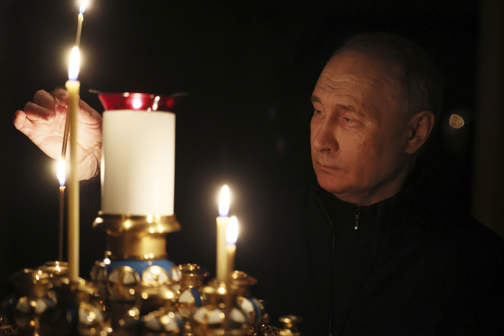 Russian President Vladimir Putin lights a candle to commemorate the victims of an attack on the Crocus City Hall concert venue, on the day of national mourning, in Russia, Sunday, March 24, 2024.