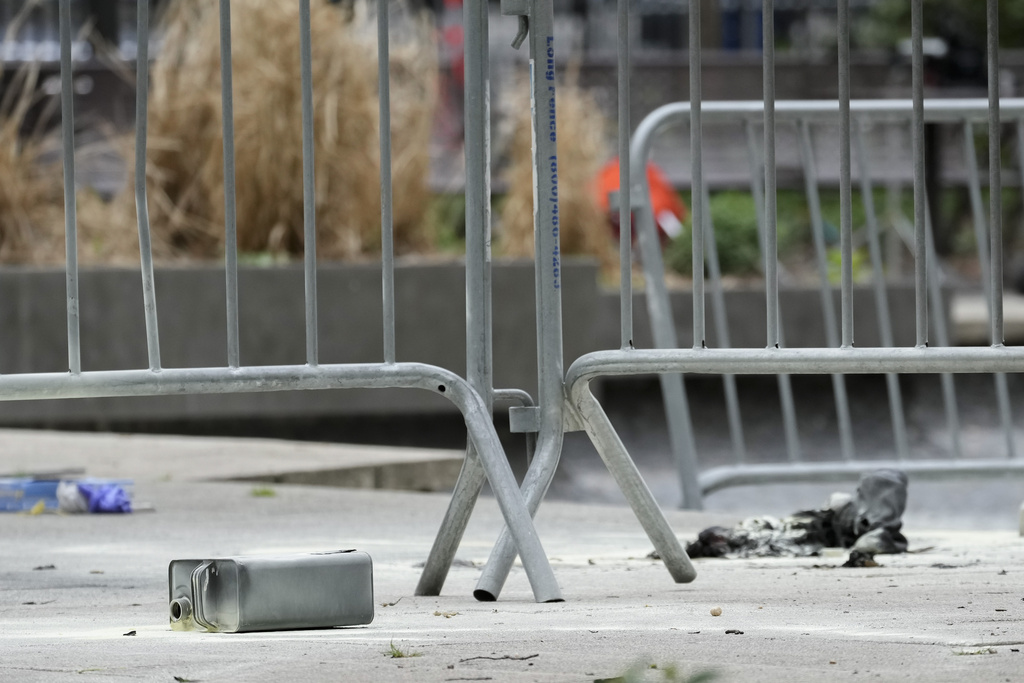 A metal can sits on the ground at the scene where a man lit himself on fire in a park outside Manhattan criminal court, Friday, April 19, 2024, at New York.