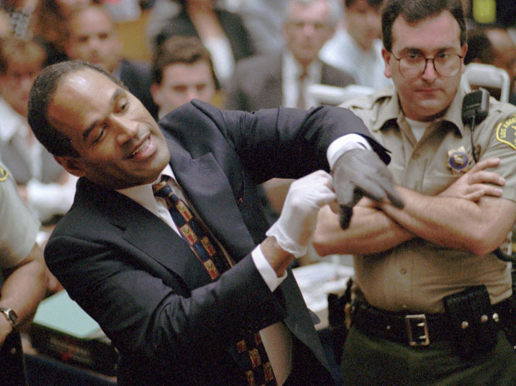 In this June 15, 1995 file photo, O.J. Simpson grimaces as he tries on one of the leather gloves prosecutors say he wore the night his ex-wife Nicole Brown Simpson and Ron Goldman were murdered in a Los Angeles courtroom.