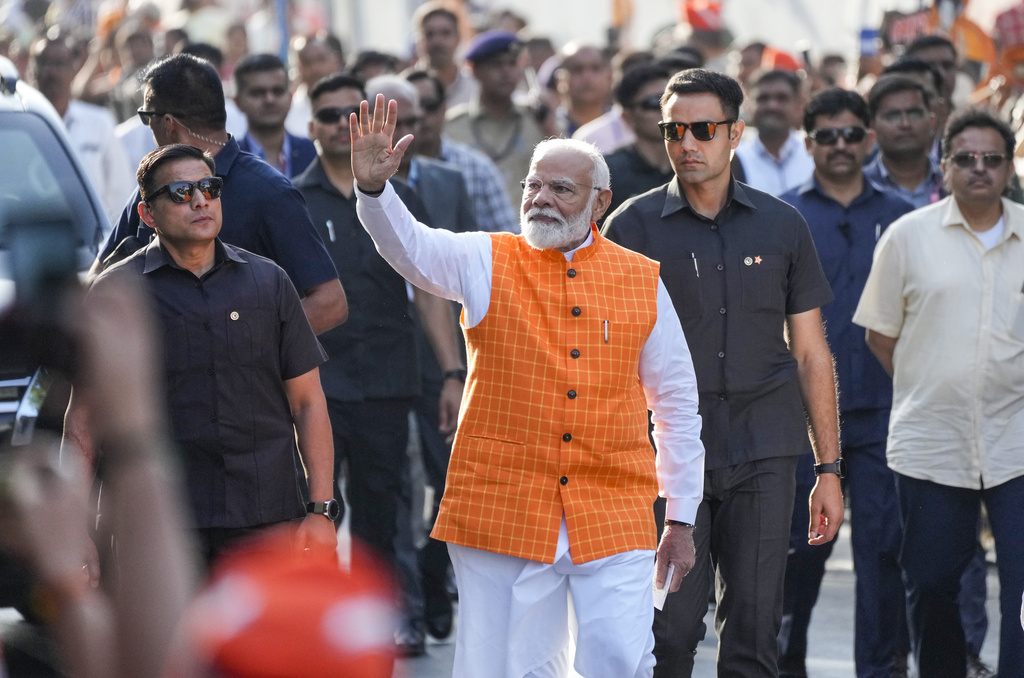 Indian Prime Minister Narendra Modi waves to people as he arrives to cast his vote during the third phase of general elections, in Ahmedabad, India, Tuesday, May 7, 2024.