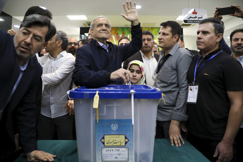In this photo provided by Iranian Students' News Agency, ISNA, reformist candidate for the Iranian presidential election Masoud Pezeshkian casts his ballot as he waves to media in a polling station, in Tehran, Iran, Friday, June 28, 2024. Iranians are voting in a snap election to replace the late hard-line President Ebrahim Raisi.