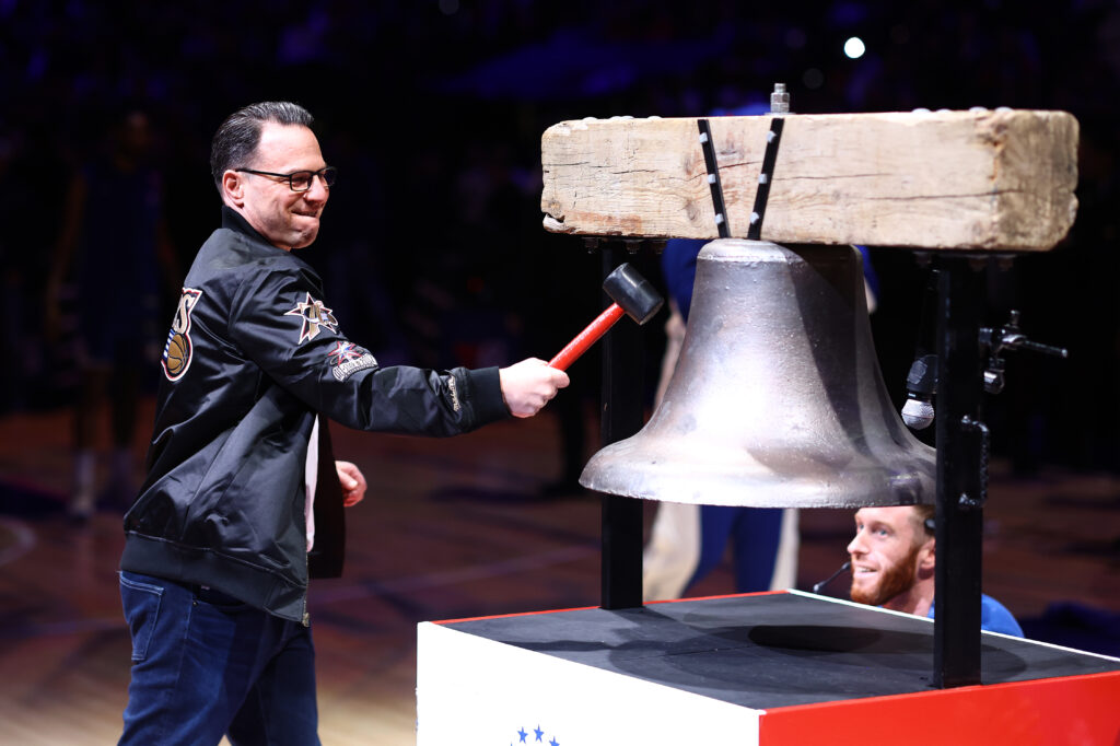 Pennsylvania's governor, Josh Shapiro, rings the bell before a game between the Philadelphia 76ers and the Miami Heat.