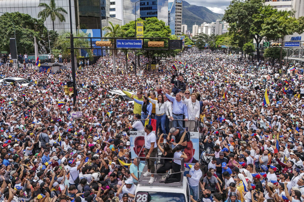 Opposition leader Maria Corina Machado and opposition candidate Edmundo Gonzalez ride atop a truck during a protest against official presidential election results declaring President Nicolas Maduro the winner in Caracas, Venezuela, Tuesday, July 30, 2024, two days after the vote.