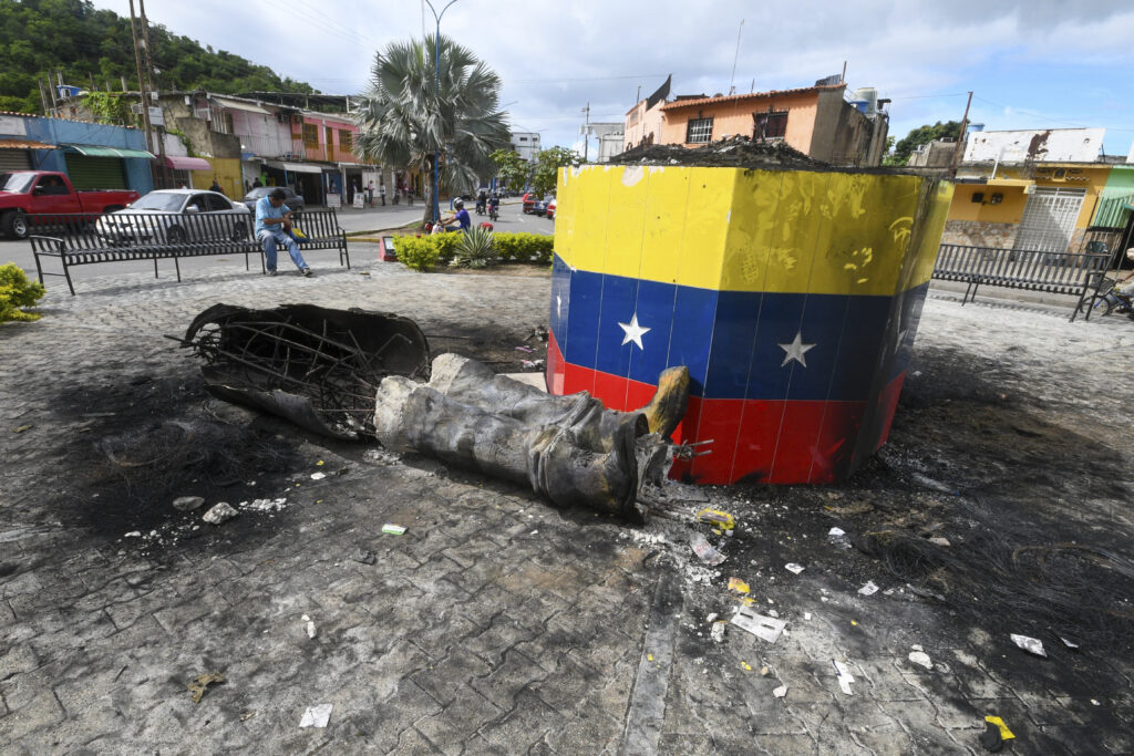 A destroyed statue of the late Venezuelan President Hugo Chavez lies next to its base in Valencia, Venezuela, Tuesday, July 31, 2024, the day after people protested the official election results that certified Chavez's protege, current President Nicolas Maduro, as the winner.