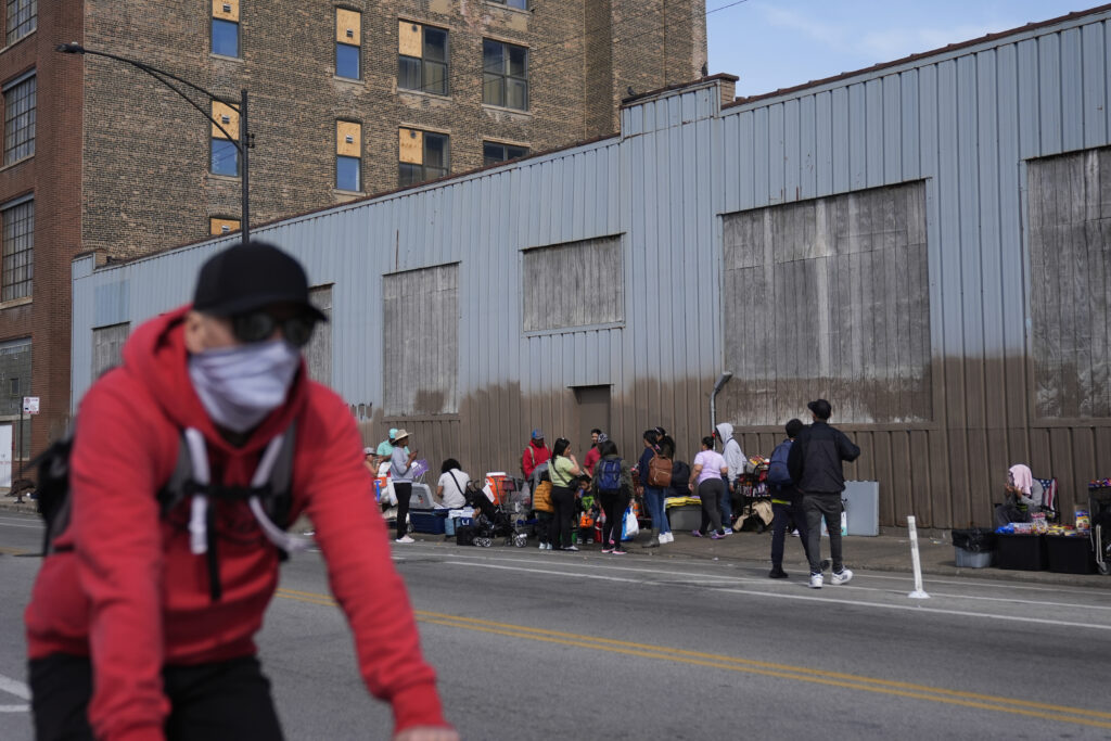 People hang around outside of a migrant shelter Wednesday, March 13, 2024, at the Pilsen neighborhood of Chicago.