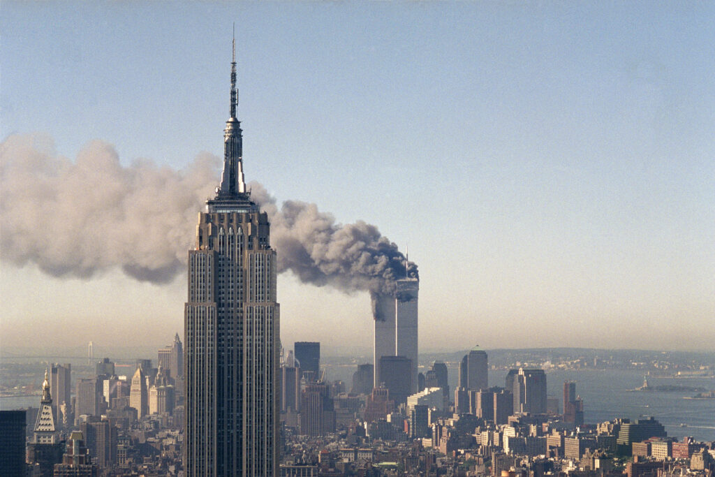 The twin towers of the World Trade Center burn behind the Empire State Building in New York on Sept. 11, 2001.