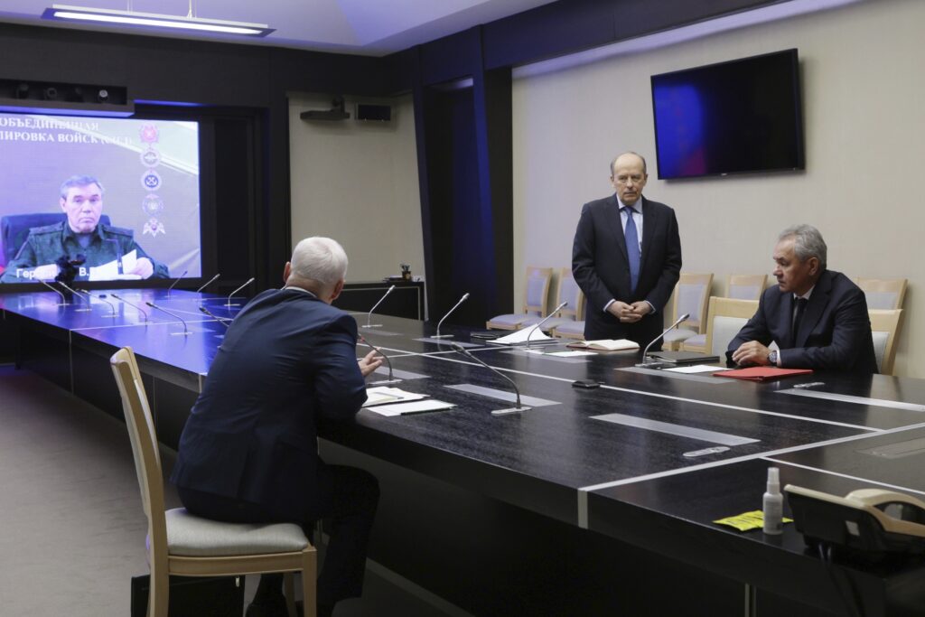 Federal Security Service Chief Alexander Bortnikov, second right, Security Council Secretary Sergei Shoigu, right, Defense Minister Andrei Belousov, back to a camera, and Russian Army Chief of General Staff Gen. Valery Gerasimov, on the screen, attend a meeting with Russian President Vladimir Putin on the situation in Kursk region, where Ukrainian armed forces attempted an offensive to seize territory at the Novo-Ogaryovo state residence, outside Moscow, Russia, on Wednesday, Aug. 7, 2024. (