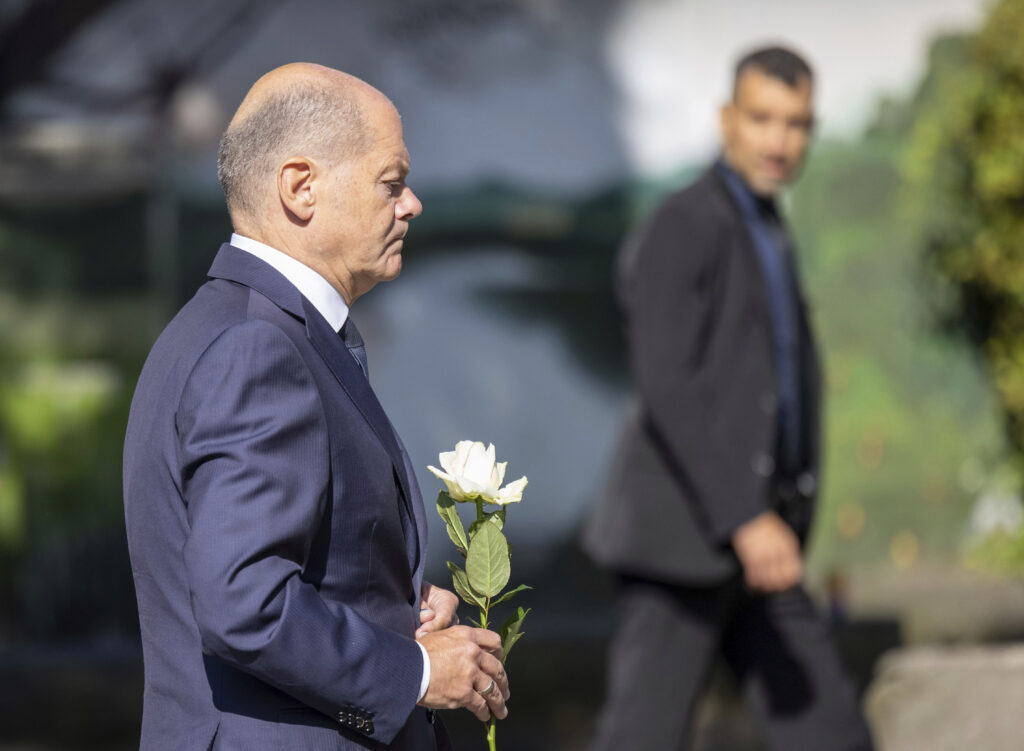 Germany Chancellor Olaf Scholz lays a flower at a church, near the scene of a knife attack, in Solingen, Germany, Monday, Aug. 26, 2024. (Thomas Banneyer/dpa via AP)