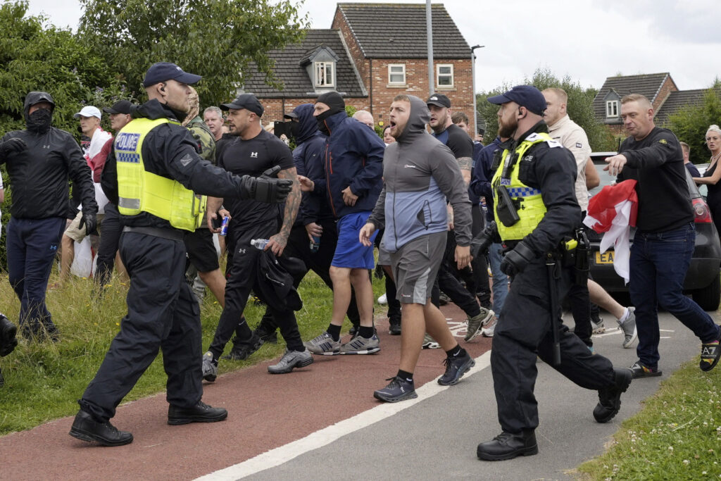 Police officers face protesters at Rotherham, England, Sunday.