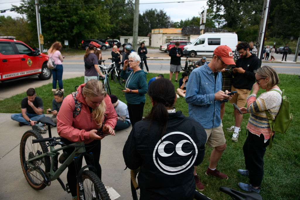 Residents gather at Fire Station number 6 to access WiFi after heavy rains from Hurricane Helene caused record flooding and damage on September 28, 2024 at Asheville, North Carolina. Cell service and internet had been down for over 48 hours.