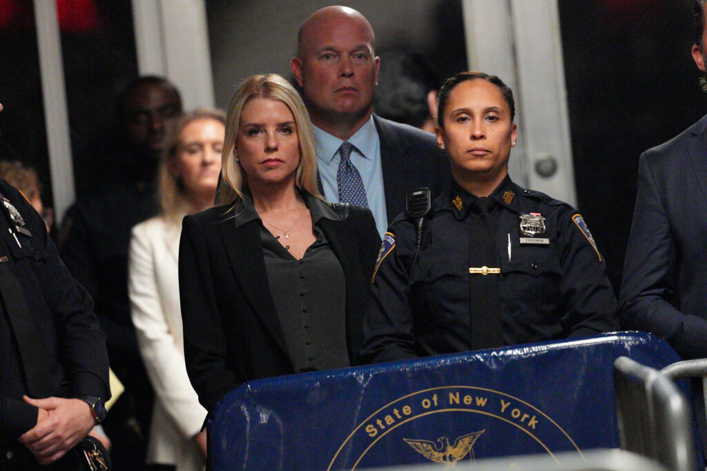 Former Florida Attorney General Pam Bondi listens as former U.S. President Donald Trump speaks to the media during his trial for allegedly covering up hush money payments at Manhattan Criminal Court on May 21, 2024 in New York City. Trump was charged with 34 counts of falsifying business records last year, which prosecutors say was an effort to hide a potential sex scandal, both before and after the 2016 presidential election. Trump is the first former U.S. president to face trial on criminal charges. (Photo by Curtis Means-Pool/Getty Images)