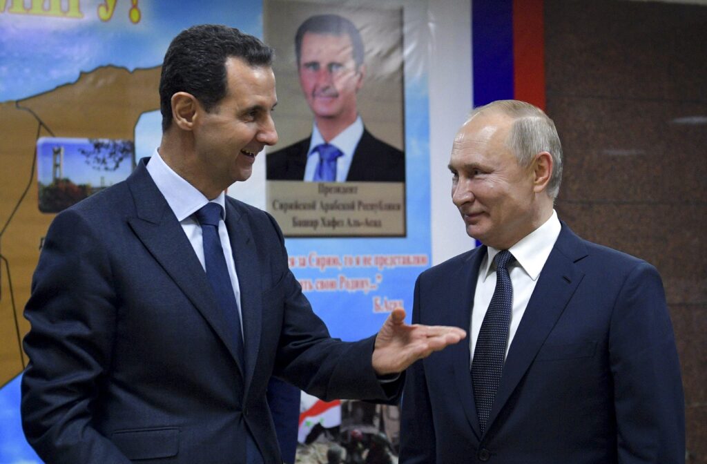 FILE - Syrian President Bashar Assad, left, gestures while speaking to Russian President Vladimir Putin during their meeting in Damascus, Syria, Jan. 7, 2020.