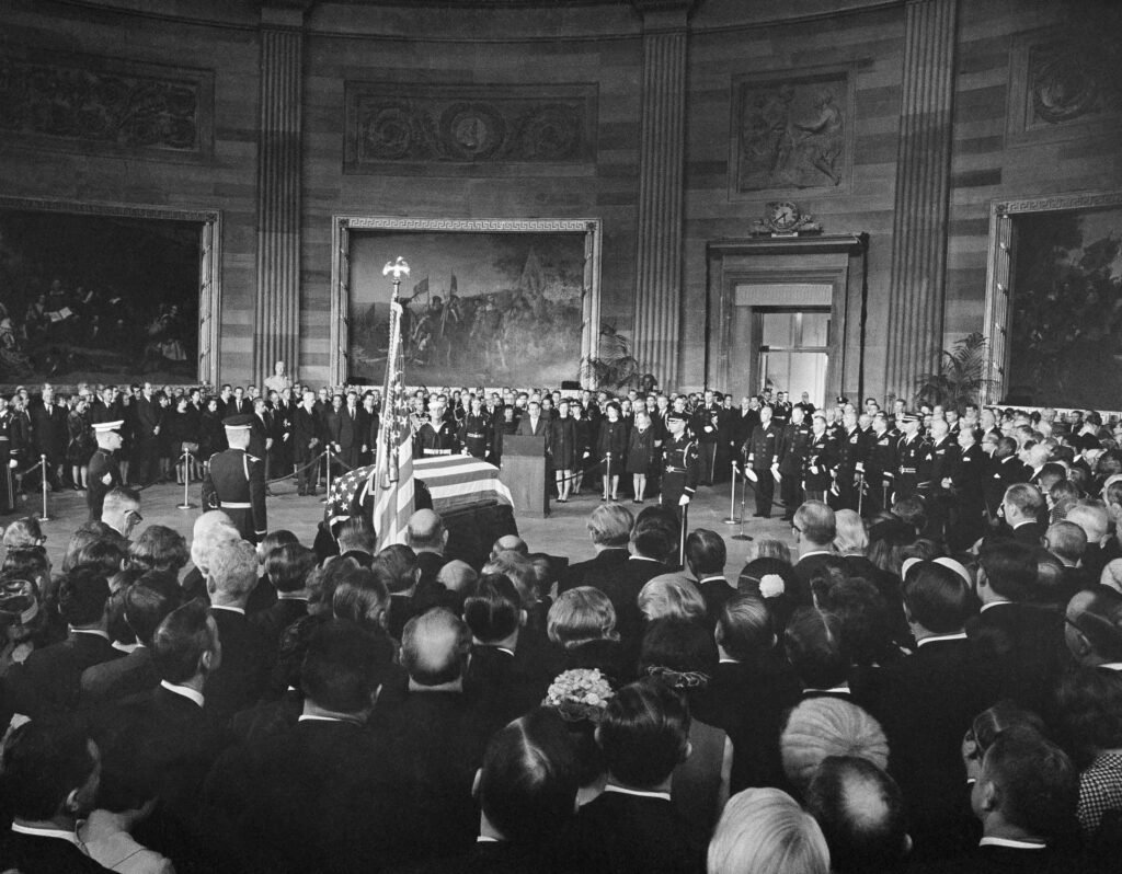 FILE - President Richard Nixon, center, speaks from a podium in front of the casket of Dwight D. Eisenhower in the Capitol Rotunda in Washington, March 30, 1969. From left, front: former first lady Mamie Eisenhower, the widow; son John Eisenhower and his wife, Barbara Eisenhower; first lady Pat Nixon and daughter Tricia.