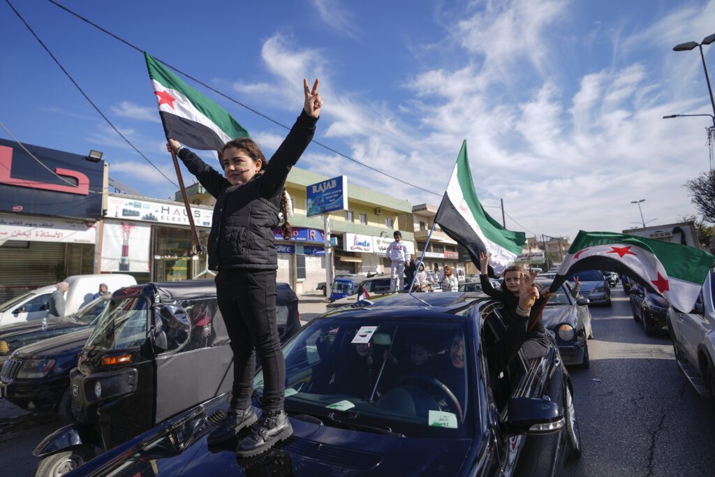 Syrians celebrate the fall of Bashar Assad's government in the town of Bar Elias, Lebanon, near the border with Syria, Sunday, Dec. 8, 2024. (AP Photo/Hassan Ammar)