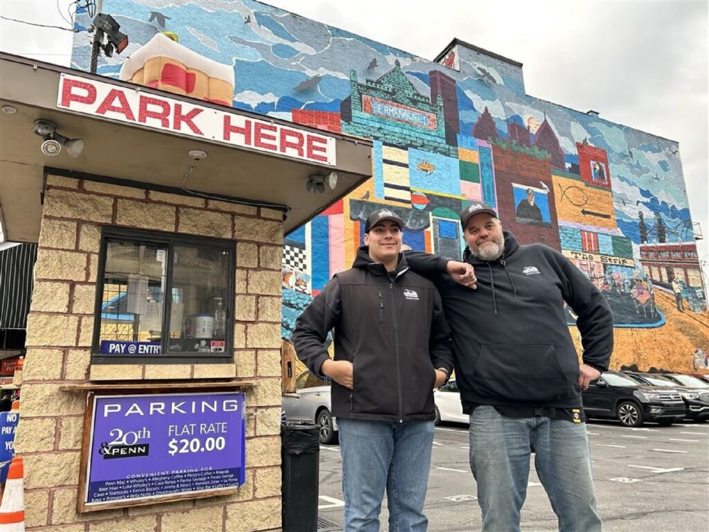 Yousef Saeed and Richard Gizzi stand in front of the 20th and Penn Avenue parking lot, where for the next ten days they will spend almost as much time carrying customers' bags from Wholey's as they will parking cars.