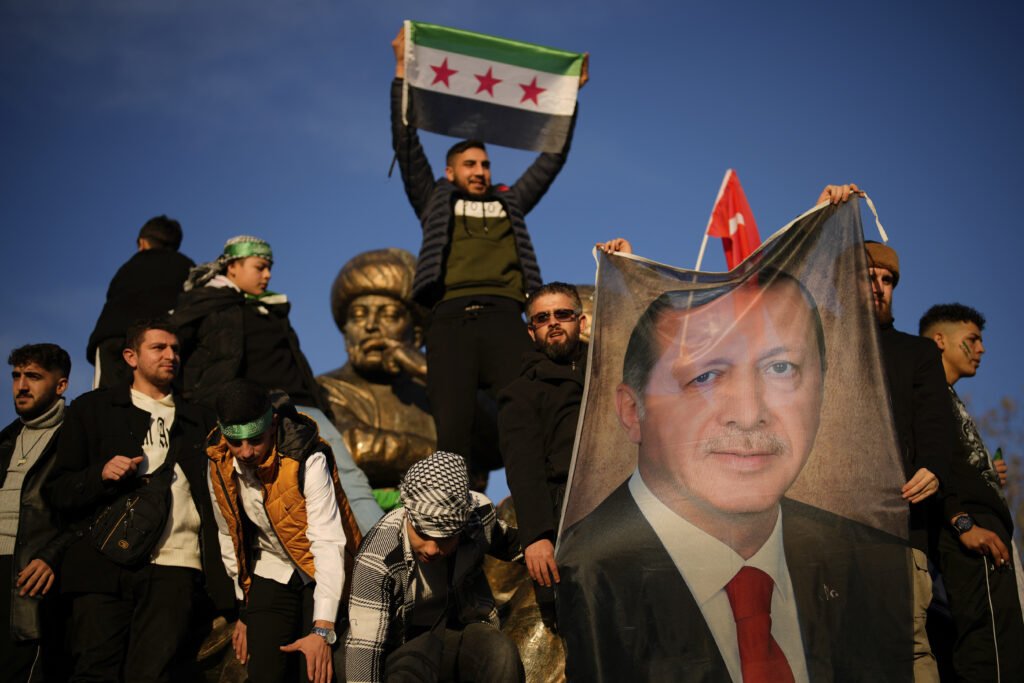People hold a banner of Turkish President Recep Tayyip Erdogan as they celebrate the fall of the Syrian government in Istanbul, Turkey, on Sunday, Dec. 8, 2024. (AP Photo/Emrah Gurel)