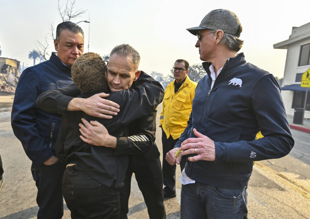 Los Angeles City Fire Captain Frank Lima, greets Los Angeles Mayor Karen Bass, as she joins Governor Newsom, right, and Senator Alex Padilla, while surveying damage during the Palisades Fire.