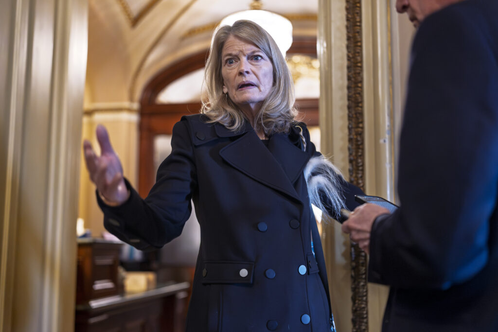 Sen. Lisa Murkowski, R-Alaska, a member of the Senate Appropriations Committee, pauses outside the chamber to answer a question from a reporter as the Senate works to avert a partial government shutdown ahead of the midnight deadline, at the Capitol in Washington, Friday, March 14, 2025. (AP Photo/J. Scott Applewhite)