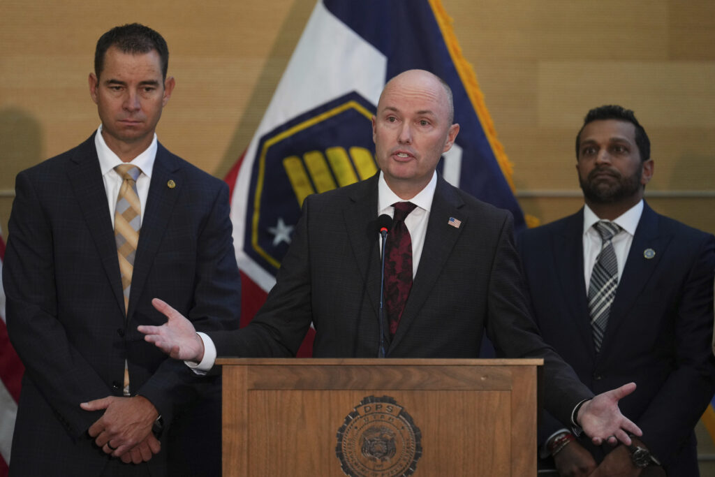 Utah Gov. Spencer Cox speaks at a news conference, as Utah department of public safety commissioner Beau Mason, left, and FBI Director Kash Patel listens, Friday, Sept. 12, 2025, in Orem, Utah,
