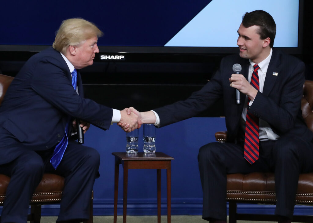 WASHINGTON, DC - MARCH 22:  U.S. President Donald Trump shakes hands with conservative activist Charlie Kirk at a forum dubbed the Generation Next Summit at the White House on March 22, 2018 in Washington, DC. The meeting brought together young Americans with members of the Trump administration to discuss the economy, tax reform and the opioid crisis. Kirk is founder of Turning Point USA, a right-wing nonprofit organization that since 2016 has maintained a watchlist of university professors that it alleges "discriminate against conservative students and advance leftist propaganda in the classroom."  (Photo by