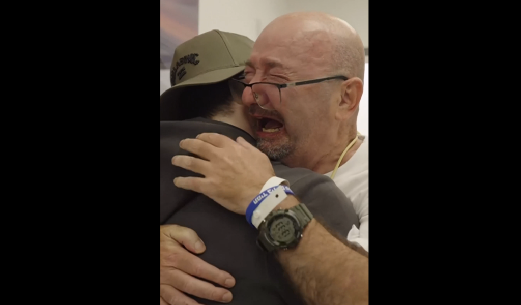 Tal Kupershtein stands up from his wheelchair to hug his son Bar, a hostage released from Hamas captivity on October 13, 2025.