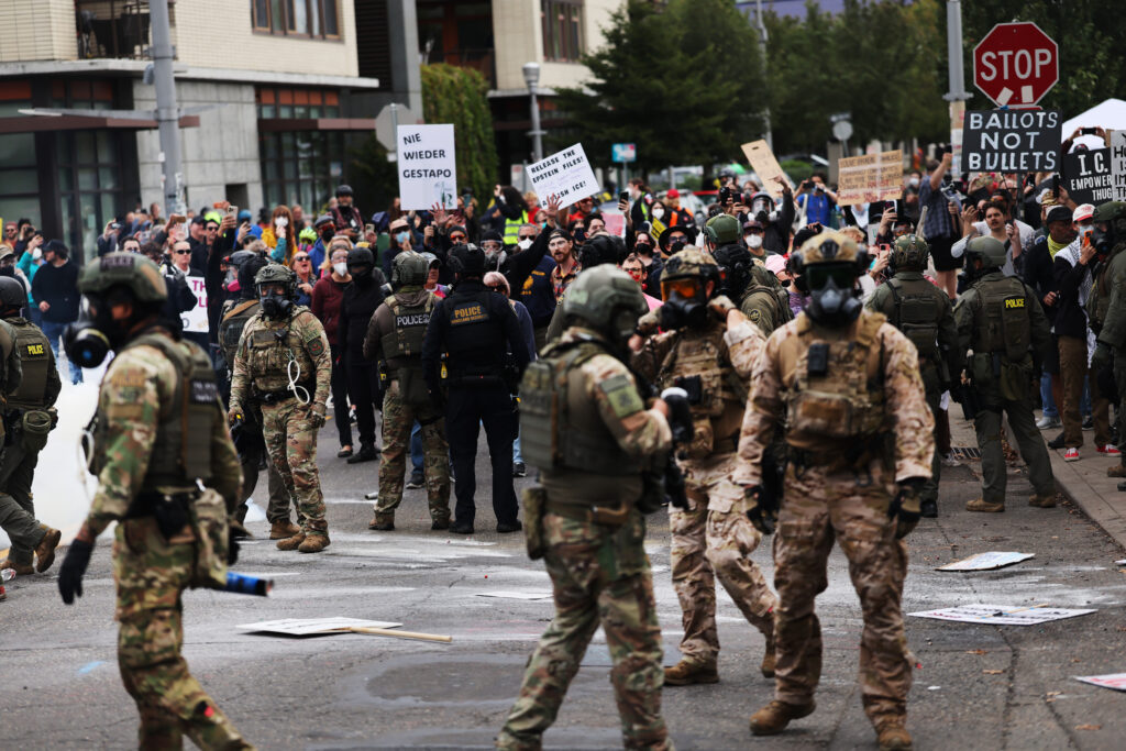 PORTLAND, OREGON - OCTOBER 04: Federal agents, including members of the Department of Homeland Security, the Border Patrol, and police, clash with protesters outside a downtown U.S. Immigration and Customs Enforcement (ICE) facility on October 04, 2025 in Portland, Oregon. The facility has become a focal point of nightly protests against the Trump administration and his announcement that he will be sending National Guard troops into Portland. A federal judge is currently hearing Oregon’s case against sending troops into the city, and a decision is expected on Saturday. (Photo by