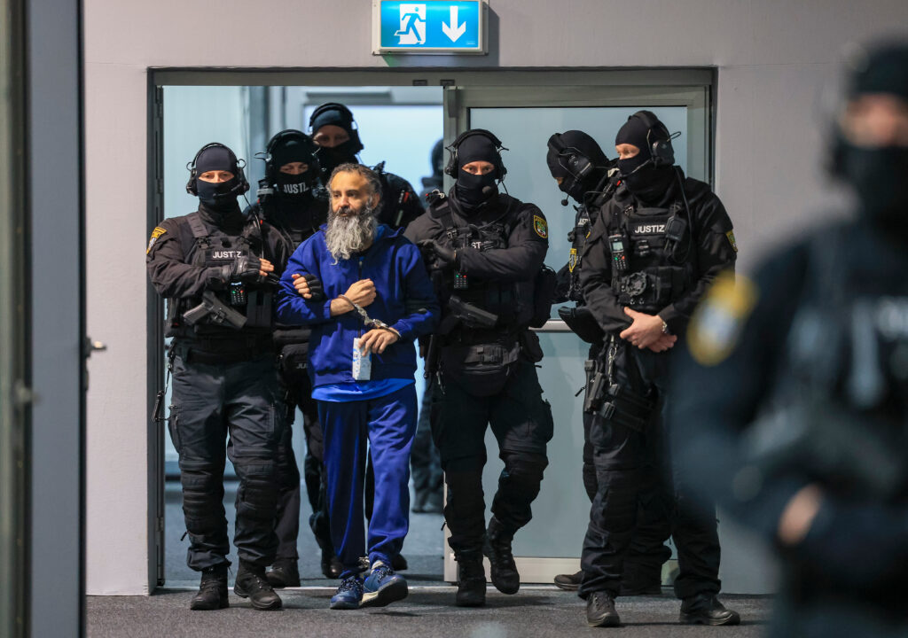 Judicial officers lead the defendant Taleb al-Abdulmohsen into the courtroom in the temporary court building of Magdeburg District Court for his trial in Magdeburg, Germany, Thursday, Nov. 20, 2025.