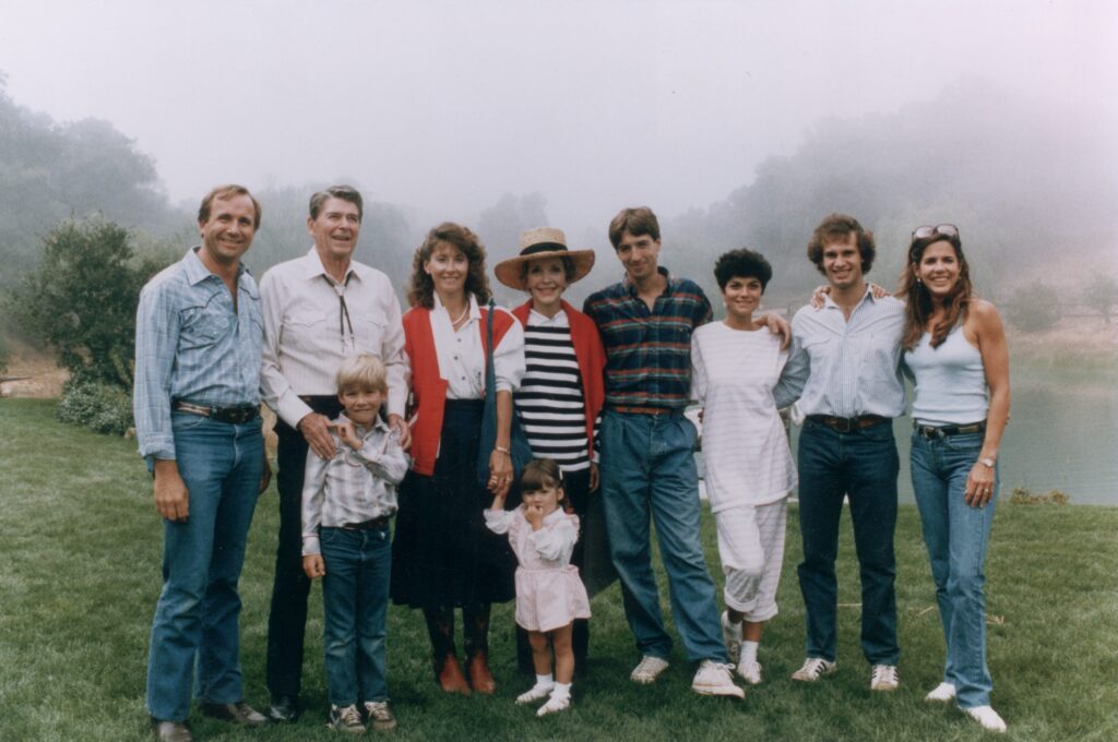 17th August 1985:  US President Ronald Reagan and First Lady Nancy Reagan pose outdoors with their family at Nancy's birthday party, Rancho Del Cielo, California. L-R: Michael, President Ronald, Cameron, Colleen, Ashley Marie, Nancy, Ron, Doria, Paul Grilley and Patti Davis. There is a foggy mist over the pond behind them.  (Photo by