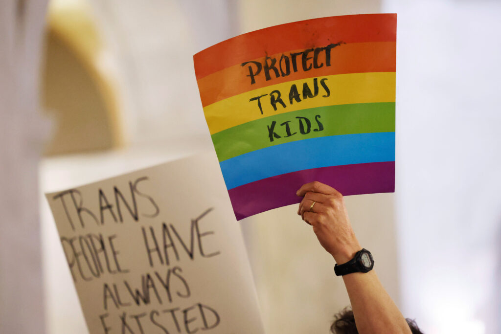 Protestors hold signs during a rally at the state capitol at Charleston, West Virginia, on March 9, 2023.